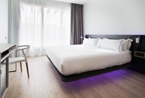 - une chambre avec un grand lit blanc et un bureau dans l'établissement B&B HOTEL Madrid Centro Puerta del Sol, à Madrid
