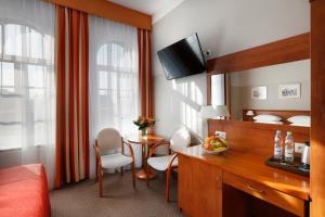 a hotel room with a bed and a desk with a table at Dom Muzyka in Gdańsk +30 photos