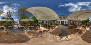 a patio with tables and chairs and umbrellas at Hotel-Landrestaurant Schnittker in Delbrück