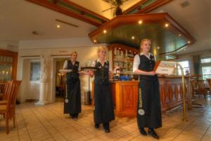 three women standing in front of a bar at Hotel-Landrestaurant Schnittker in Delbrück