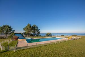 una vista aérea de una piscina con el océano en el fondo en Your Nest in Nazaré - Ocean View Villa, en Nazaré