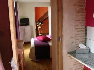 a bedroom with a bed with pink pillows at L'Ancien Presbytère in Luzy