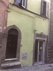 a yellow building with a doorway and a door at La Torre Nel Borgo in Viterbo