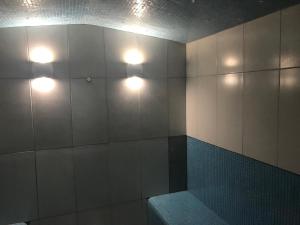 un baño con 2 luces en una pared con un banco en Loughborough Grange Guesthouse & Spa en Loughborough