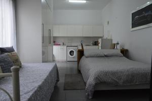 een kleine kamer met 2 bedden en een keuken bij St. Lazaros Studios in Larnaka
