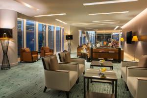 a hotel lobby with chairs and tables and windows at Fraser Suites Riyadh in Riyadh