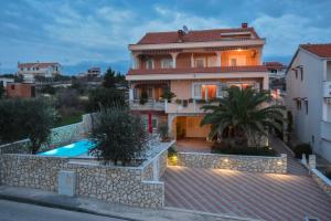 a house with a swimming pool in front of it at Villa Mateja in Novalja