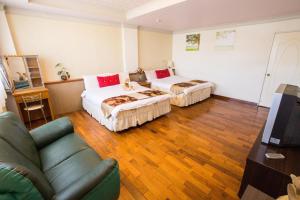 una habitación de hotel con dos camas y un sofá en 台東耕園民宿-彭家民宿聯盟, en Taitung