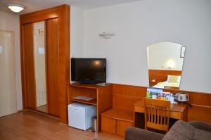 een woonkamer met een tv op een houten kast bij Garni Hotel Lake in Čačak