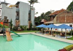 una grande piscina con scivolo di fronte a un edificio di RedDoorz Hostel @ Dago 2 a Bandung