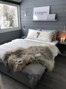 a bedroom with a bed with a fur blanket on it at Storehorn Apartments in Hemsedal