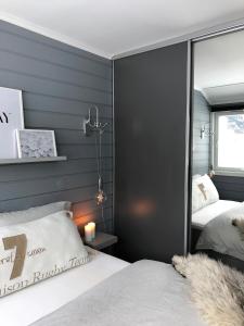 two beds in a bedroom with gray walls at Storehorn Apartments in Hemsedal