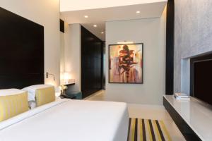 a bedroom with a bed and a painting on the wall at Fraser Suites Riyadh in Riyadh +38 photos