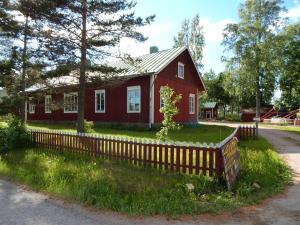 a red house with a fence in front of it at Cirkus Hostel Holken in Inkoo