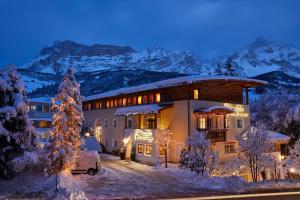 ein Haus mit einem Weihnachtsbaum davor in der Unterkunft Dolomit Boutique Hotel in Stern