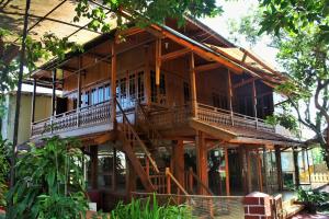 a large wooden house with a staircase in front of it at RedDoorz Hostel @ Dago 2 in Bandung