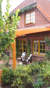 uma casa de tijolos vermelhos com um banco no quintal em Gästeappartement Appricot em Adendorf