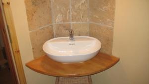 a white sink on a wooden stand in a bathroom at Gästeappartement Appricot in Adendorf