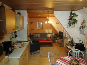 een keuken en een woonkamer met een bank in een kamer bij Haus-Kummeleck-Wohnung-1 in Bad Lauterberg