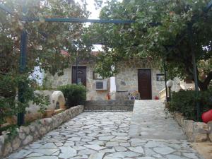a stone walkway in front of a house at Mantas Bay in Vouliagmeni Lake