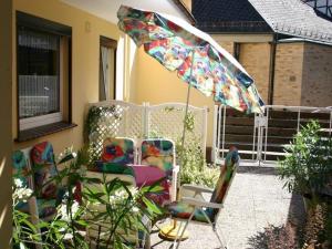 patio z 2 krzesłami i parasolem w obiekcie Haus-Kummeleck-Wohnung-4 w mieście Bad Lauterberg