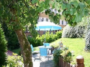 een patio met een tafel en stoelen en een parasol bij Haus-Kummeleck-Wohnung-4 in Bad Lauterberg