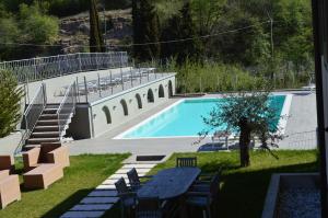 - une piscine avec une table et des chaises dans la cour dans l'établissement Residence La Villa Tignale, à Tignale
