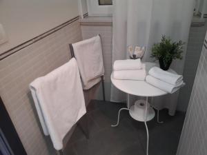 a white toilet sitting next to a white towel rack at Monnalisa Village - Cobra Car in Fiumicino
