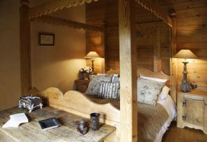 um quarto com uma cama de madeira e um espelho grande em Chalet Chatel, avec services, Collection Chalets des Fermes - Megève em Megève