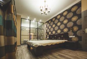 a bedroom with a large bed and a chandelier at Kapitan Apartments in Odesa