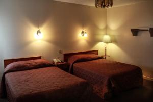Harbour GraceにあるHotel Harbour Graceのベッド2台 ホテルルーム 壁に照明付