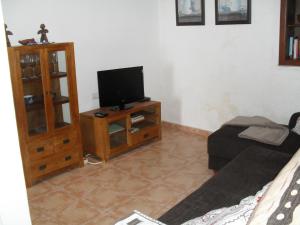 a living room with a tv on a wooden cabinet at Casa Rural Arguamul in Vallehermoso
