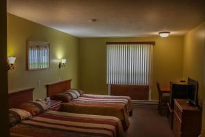 a hotel room with two beds and a television at Hotel Harbour Grace in Harbour Grace