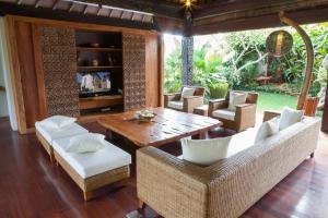 sala de estar con mesa de madera y sillas en Swarapadi Villa en Ubud