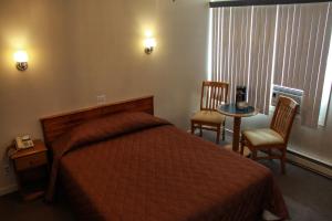 a hotel room with a bed and a table and chairs at Hotel Harbour Grace in Harbour Grace