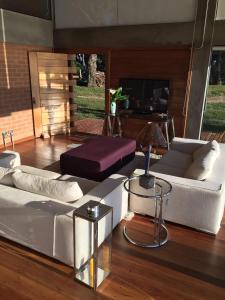 a living room with a white couch and a table at Chalet nas Nuvens with Infinity Pool in São Bento do Sapucaí
