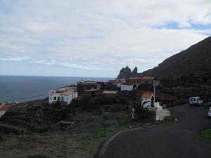 ein Dorf an der Seite eines Hügels mit dem Meer in der Unterkunft Casa Rural Arguamul in Vallehermoso