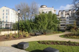 un parco con panchina e un edificio di Best Western Rives de Paris La Defense a Courbevoie