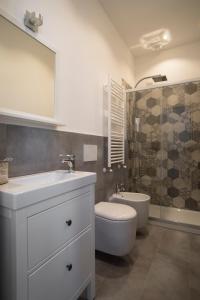 uma casa de banho com um lavatório, um WC e um chuveiro em La Maison Extravagante em Saronno