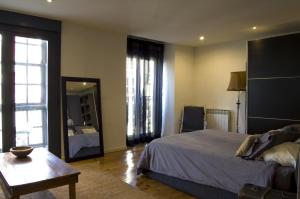 1 dormitorio con cama, mesa y espejo en Apartamentos Ondoloin, en Vitoria-Gasteiz