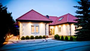 une maison avec un toit rose dans une allée dans l'établissement Villa Hof, à Luboń