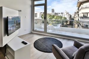 uma sala de estar com um sofá e uma grande janela em Flaat Recoleta Plaza em Buenos Aires