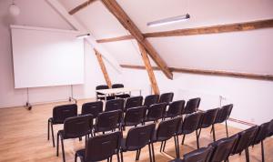 an empty lecture hall with chairs and a white screen at Strand Golf in Harad