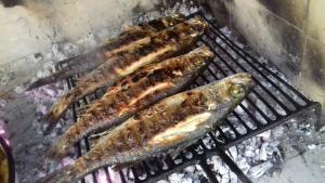 a group of fish cooking on a grill at Apartment Old village in Trstenik