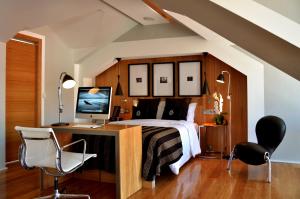 里斯本的住宿－布朗市中心酒店，一间卧室配有一张床和一张带电脑的书桌