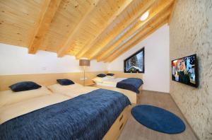 スピンドレルフ・ムリンにあるApartmány Hromovkaのベッド2台、壁掛けテレビが備わる客室です。