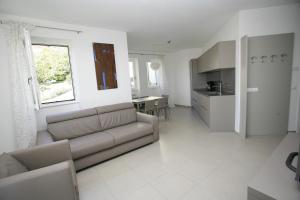 un salon avec un canapé et une cuisine dans l'établissement Residence La Villa Tignale, à Tignale