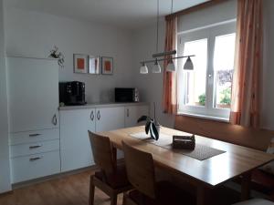 a kitchen with a wooden table and a dining room at Haus Sonnenheim in Frastanz