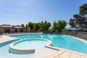 ソルマーヌ・ド・ボークリューズにあるMadame Vacances Domaine du Provence Country Club Service Premiumの大きなスイミングプール(椅子付)