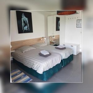 ein Schlafzimmer mit einem großen Bett in einem Zimmer in der Unterkunft De Hollemeersch Hotel in Dranouter